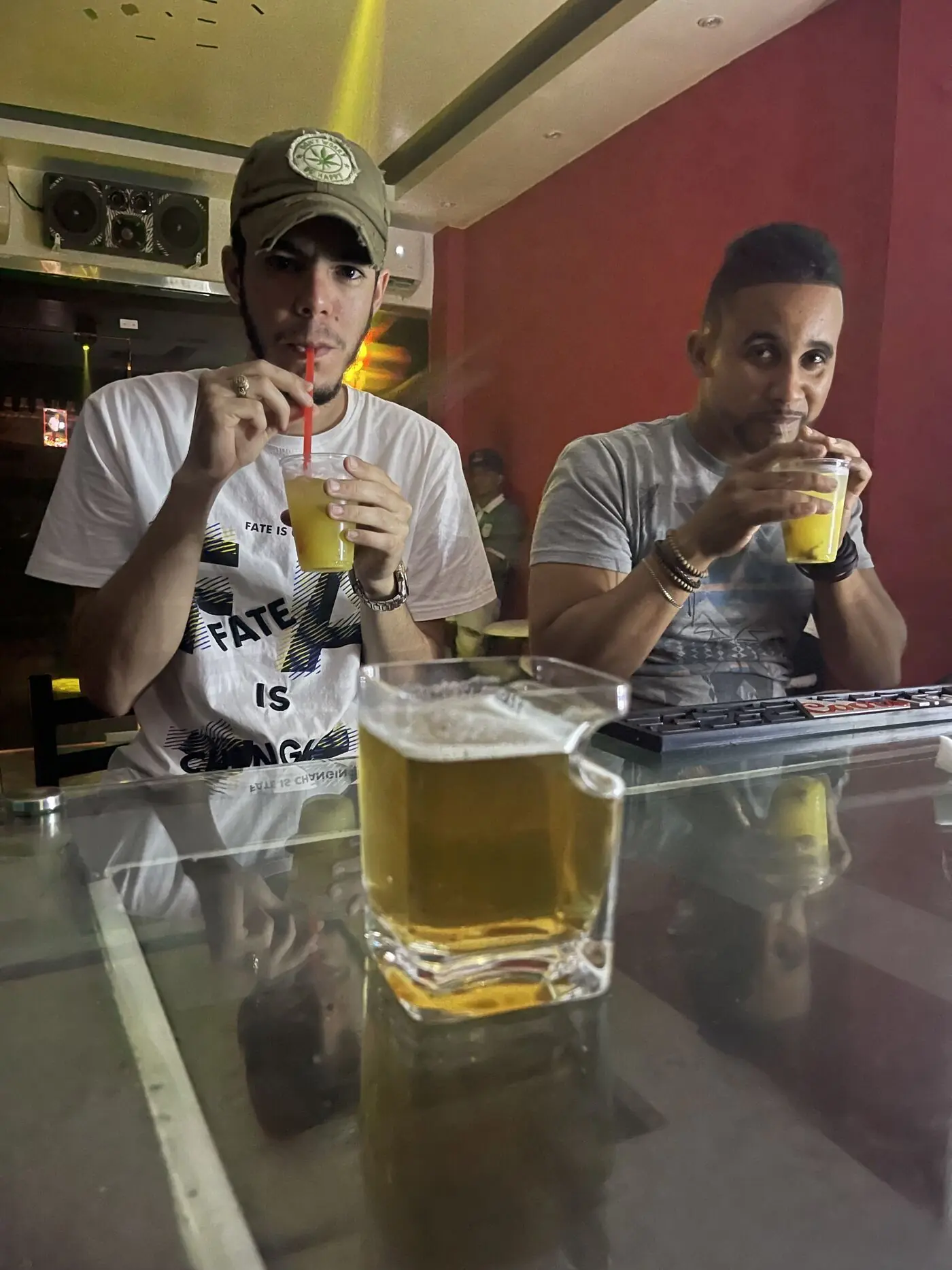 Dos amigos en la barra tomándose algo frente a un vaso de cerveza