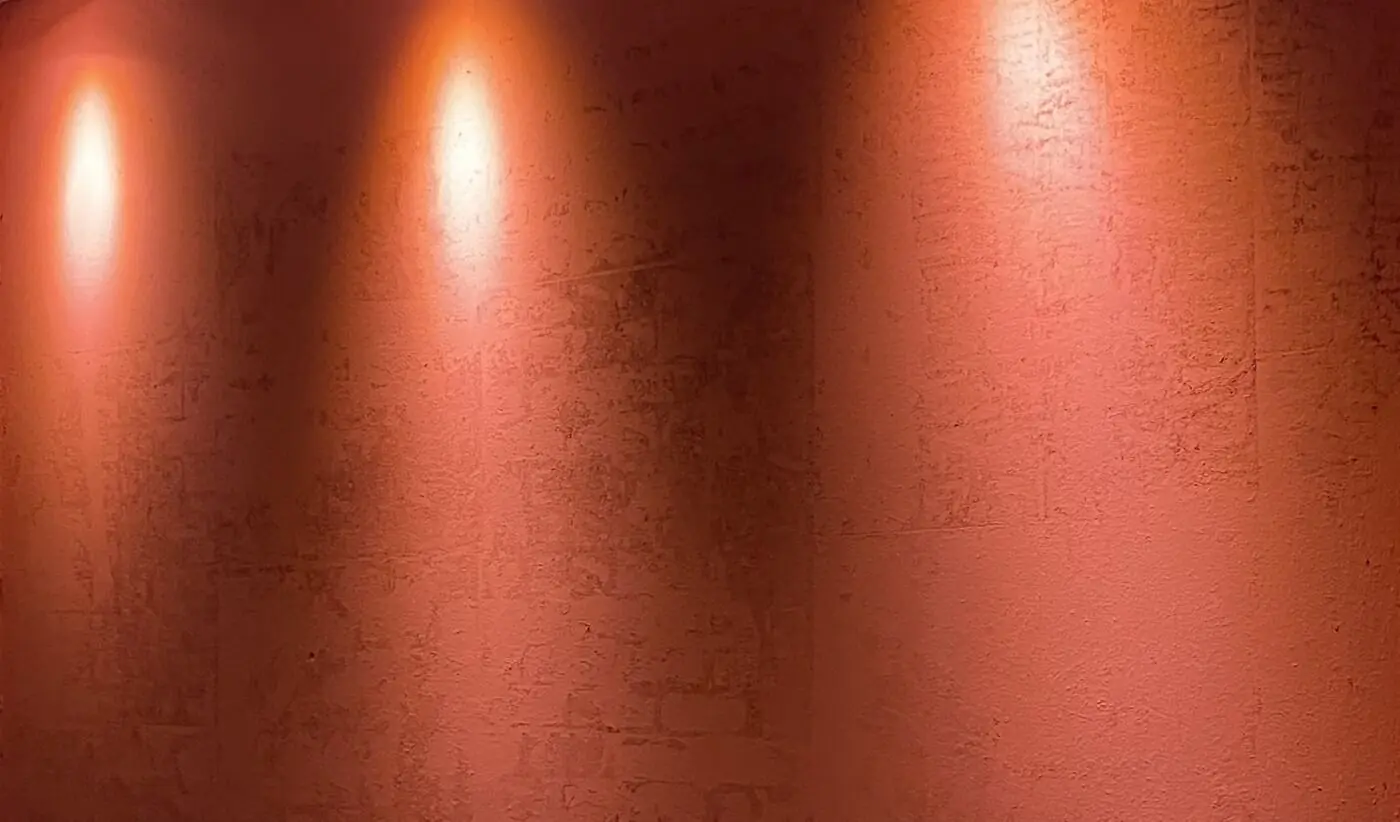 La pared terracota del bar con tres luces cálidas encima