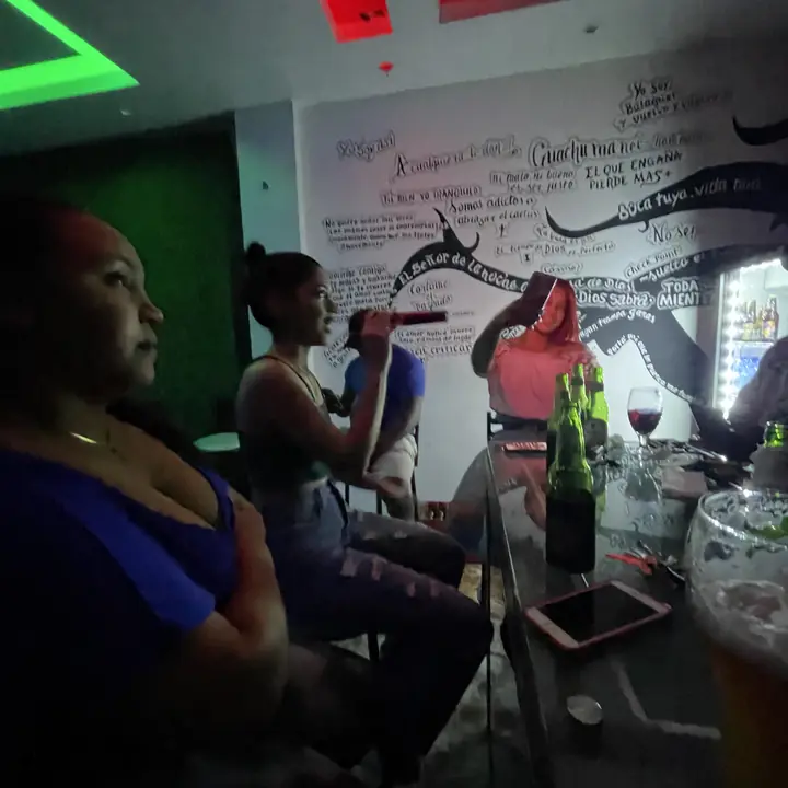 Gente conversando frente a la pared escrita del bar